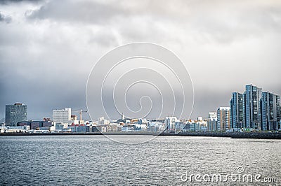 Reykjavik seascape dramatic cloudy sky. City on sea coast Iceland. Scandinavian seascape concept. Calm water surface and Stock Photo