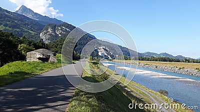 The rhine river and bicycle path with mountain and blue sky on the background Stock Photo
