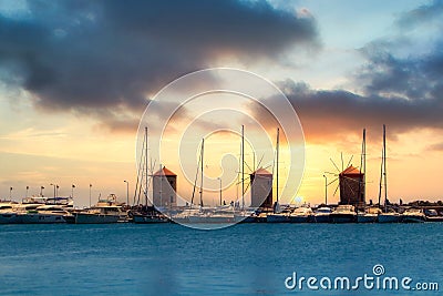 The port of Rhodes with its historic windmills at sunset Editorial Stock Photo