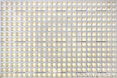 Rhythmic texture on suspended ceiling with rows of halogen spots lamps and drywall construction with chandelier. Stretch ceiling Stock Photo