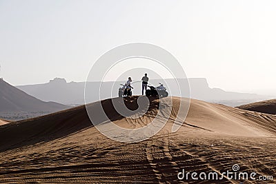 Riad, Saudi Arabia, February 15 2020: Two young Saudis take a break with their quads on the top of a red sand dune south of Riyadh Editorial Stock Photo