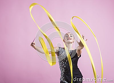 Ribbon for rhythmic gymnastics at sport woman. ribbon for rhythmic gymnastics in hand of girl on pink background Stock Photo