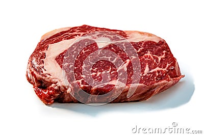 Ribeye. A raw marbled beef steak sits on a white background with a shadow Stock Photo