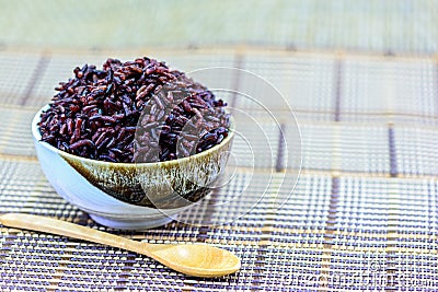 Rice berry in bowl with wooden spoon Stock Photo