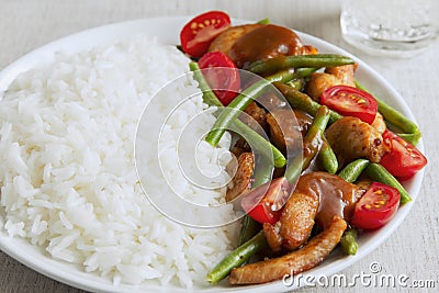 Rice with chicken fillet green beans tomato and sauce Stock Photo