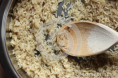 Rice frying and oiling in ghee on steel pan closeup, process of cooking asian indian basmati ghee rice Stock Photo