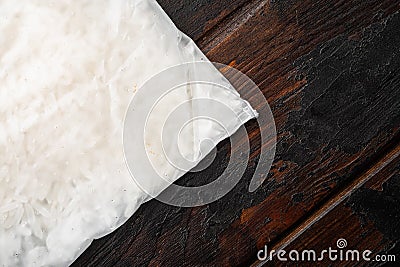 Rice in portion bags, on old dark wooden table background, top view flat lay, with copy space for text Stock Photo