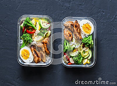 Rice, stewed vegetables, egg, teriyaki chicken - healthy balanced lunch box on a dark background, top view. Home food for office Stock Photo