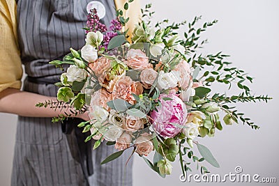 Rich bunch of pink peonies and white eustoma roses flowers, green leaf in glass vase. Fresh spring bouquet. Summer Stock Photo