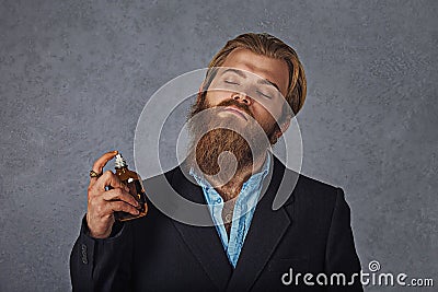 Rich man expensive using perfume cologne isolated grey background Stock Photo