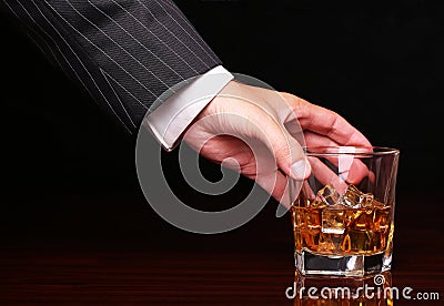 Rich and success business man holding in hand glass of whiskey Stock Photo