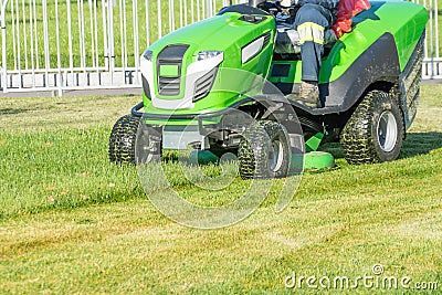 Ride lawn mower mows a green fresh grass Stock Photo