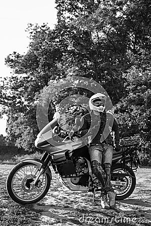 rider guy use smart phone in jeans biker jacket and helmet sit on tourist touring motorcycle. outdoors, dual sport adventure Stock Photo