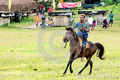 Rider on horse with lasso and spear at Pasola Festival, Kodi, Sumba Island, Nusa Tenggara Editorial Stock Photo