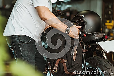 Rider install a motorcycle saddlebag or side bag on luggage bracket vintage motorbike motorcycle travel concept. selective focus Stock Photo