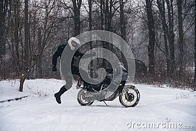 Rider man jump near adventure motorcycle. Winter fun. snowy day. the snow fall. off road dual sport crazy extreme ride, active Stock Photo
