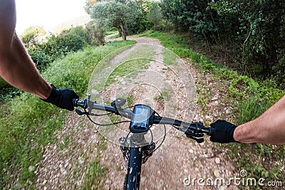 Riding a black mountain bike with nav on a gravel mountain road from a rider chest point of view Stock Photo