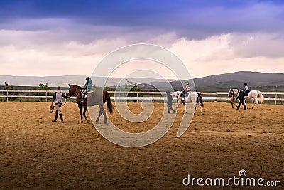 Riding horses on the arena with trainers and kids Editorial Stock Photo