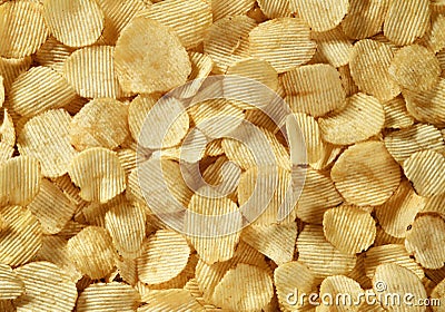 Riffle golden chips with texture potato background Stock Photo