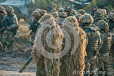 rifle in hands of sniper at camouflage ghillie suit. Army parade soldiers Editorial Stock Photo