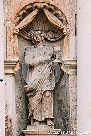 Riga Latvia. Close Ancient Statue Of Man With Bowl On Facade Of St. Peter Church, Stock Photo