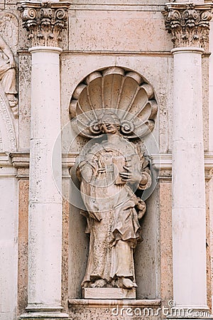 Riga Latvia. Close Ancient Statue Of Woman With Open Book Between Two Pillars On The Facade Of St. Peter Church, Stock Photo