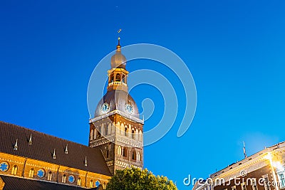 Riga Latvia. Close Illuminated Tower Of Dome Cathedral. Evening Stock Photo