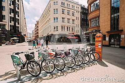 Riga, Latvia. Row Of Colorful Bicycles For Rent At Municipal Bike Parking In Kalku Street, Popular Showplace Of Old Town Editorial Stock Photo