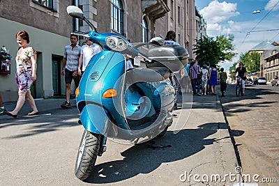 RIGA, LATVIA - MAY 24, 2014: Miera street Pentecost. Side of the street stands scooter. People walking down the street Editorial Stock Photo