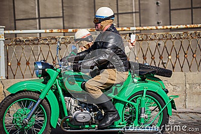 Couple with green Ural motorcycle participates at Riga Retro 2019 Editorial Stock Photo