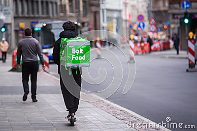 Bolt Food food delivery worker rides with scooter Editorial Stock Photo