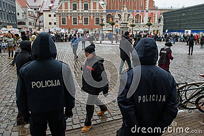 Two police officers standing in front of crowd with participants of `March for animals` in Riga, Latvia. Editorial Stock Photo