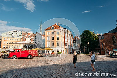 Riga, Latvia. Two Young People Women Walking And Taking Pictures Editorial Stock Photo