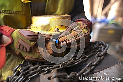 Rigger wearing a glove inspecting using blue plastic tag and tagging a heavy duty 2 tone chain hoist lifting equipment Stock Photo