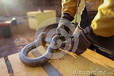 Rigger wearing a safety glove inspecting, tagging safety crane lifting 17 tone equipment with green plastic tag prior used Stock Photo