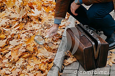 Big round magnifier on long handle in hand of naturalist Stock Photo