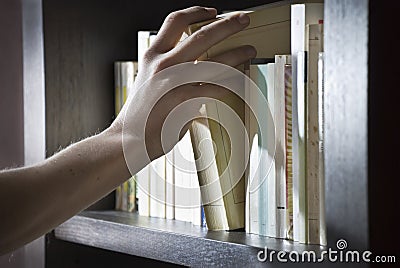 Right hand reaching for a book Stock Photo