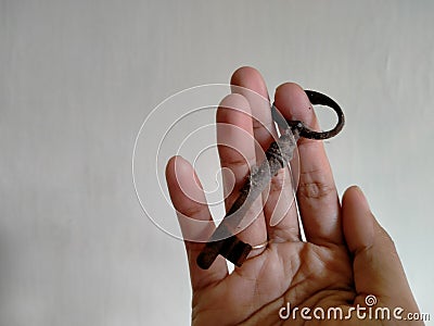Right hand holding a unique rusty key on a white background Stock Photo