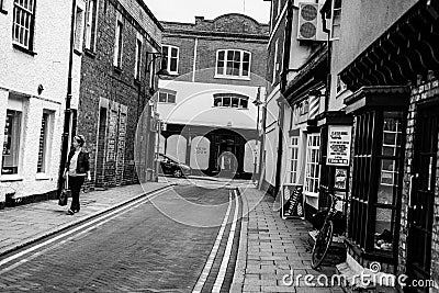 Loan woman seen walking down a deserted side-street in an English town. Editorial Stock Photo