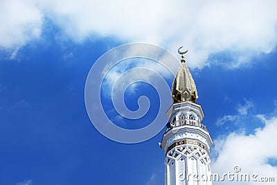 The right tower (minaret) of the mosque in a sunny day against the blue sky Stock Photo