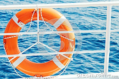Ring life buoy on boat. Obligatory ship equipment. Orange lifesaver on the deck of a cruise ship. Stock Photo