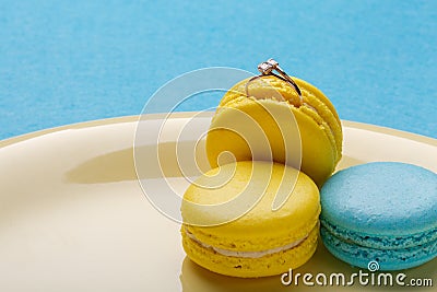 Hide a wedding ring in come to a macaroon. the offer to marry. place for text Stock Photo