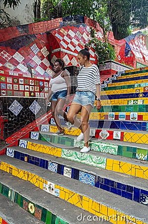 Brazilian girls walk down the colorful steps of the famous Stairway Selaron Escadaria Editorial Stock Photo