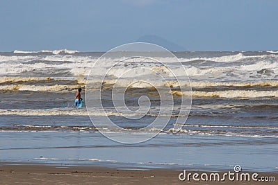 Local Brazilian fishermen fish net among large waves on the shore of the Atlantic Ocean Editorial Stock Photo