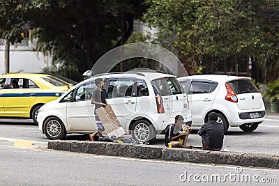 RIO DE JANEIRO, BRAZIL - May 27, 2020: Children begging and eating on the side of an urban road in Rio de Janeiro Editorial Stock Photo