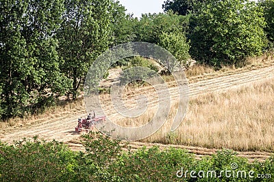 Agriculturer, field worker, peasant, ploughing a field and harvesting hay with its tractor in Ripanj, in the Serbian countryside, Editorial Stock Photo