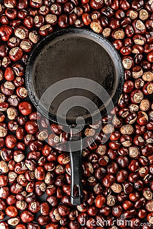Ripe chestnuts and black chestnut pan ready for roasting. Food autumn concept with copy space Stock Photo