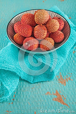 Ripe, colorful lichees decorated on turquoise background with napkin Stock Photo