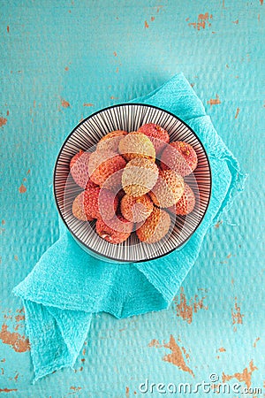 Ripe, colorful lichees decorated on turquoise background with napkin Stock Photo