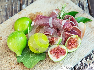 Ripe fig fruits and bacon or prosciutto. Food to accompany the drinks Stock Photo